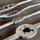 Különböző méretű menetfúró-foglalatok és régi, kézi kovácsolású menetvágó. Fotó: Toró Attila.